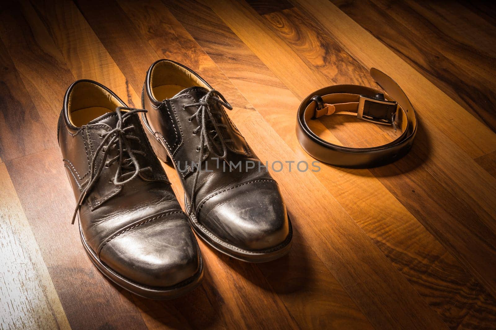 Stylish Black Handcrafted Dress Shoes and Leather Belt on Wooden Floor Spotlight Sun Clothing