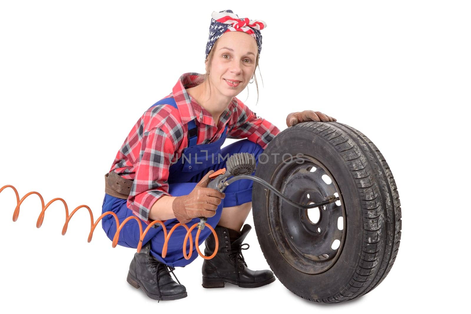 Vintage and young woman inflates a car tire on the white background