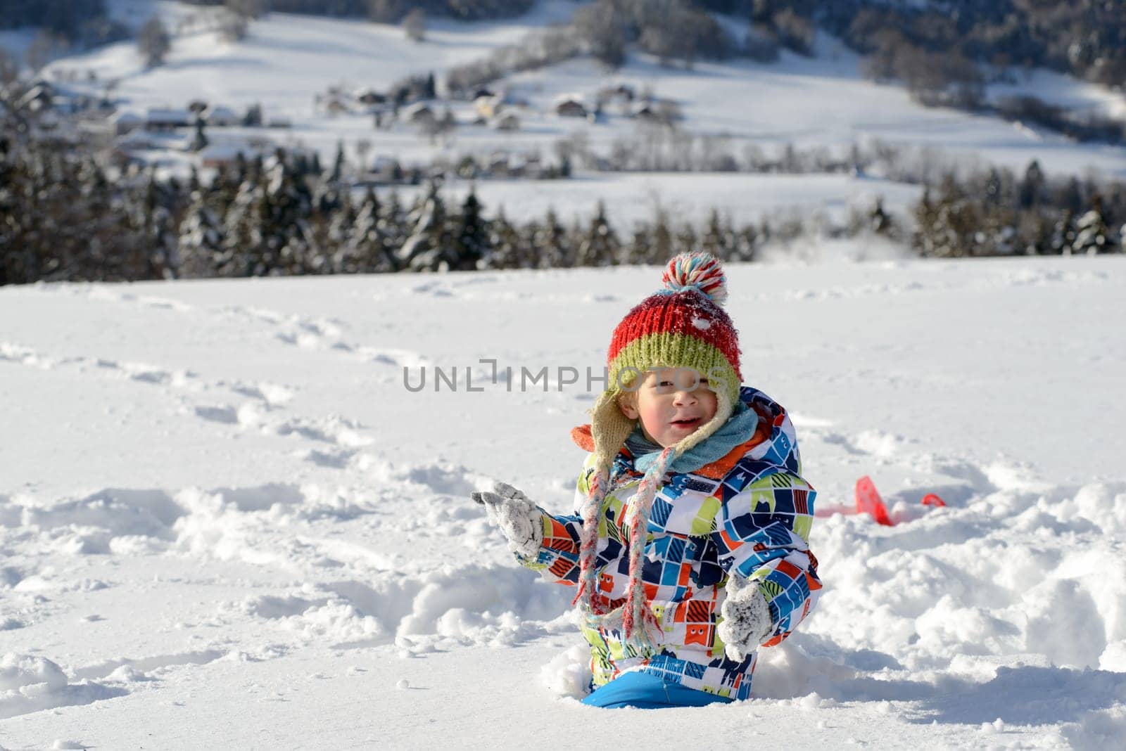 little 3 year old child playing in the snow