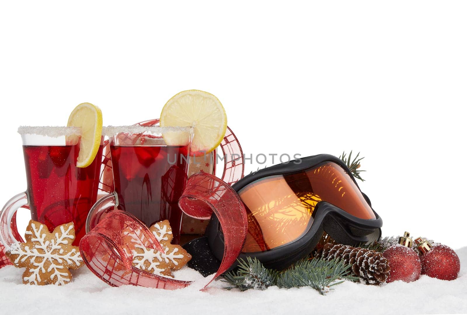 Winter holidays still life with fir tree branch, ski glasses, fruit tea, gingerbread cookies and Christmas decorations lying on snow with copy space. New Year and Christmas. Winter vacation.