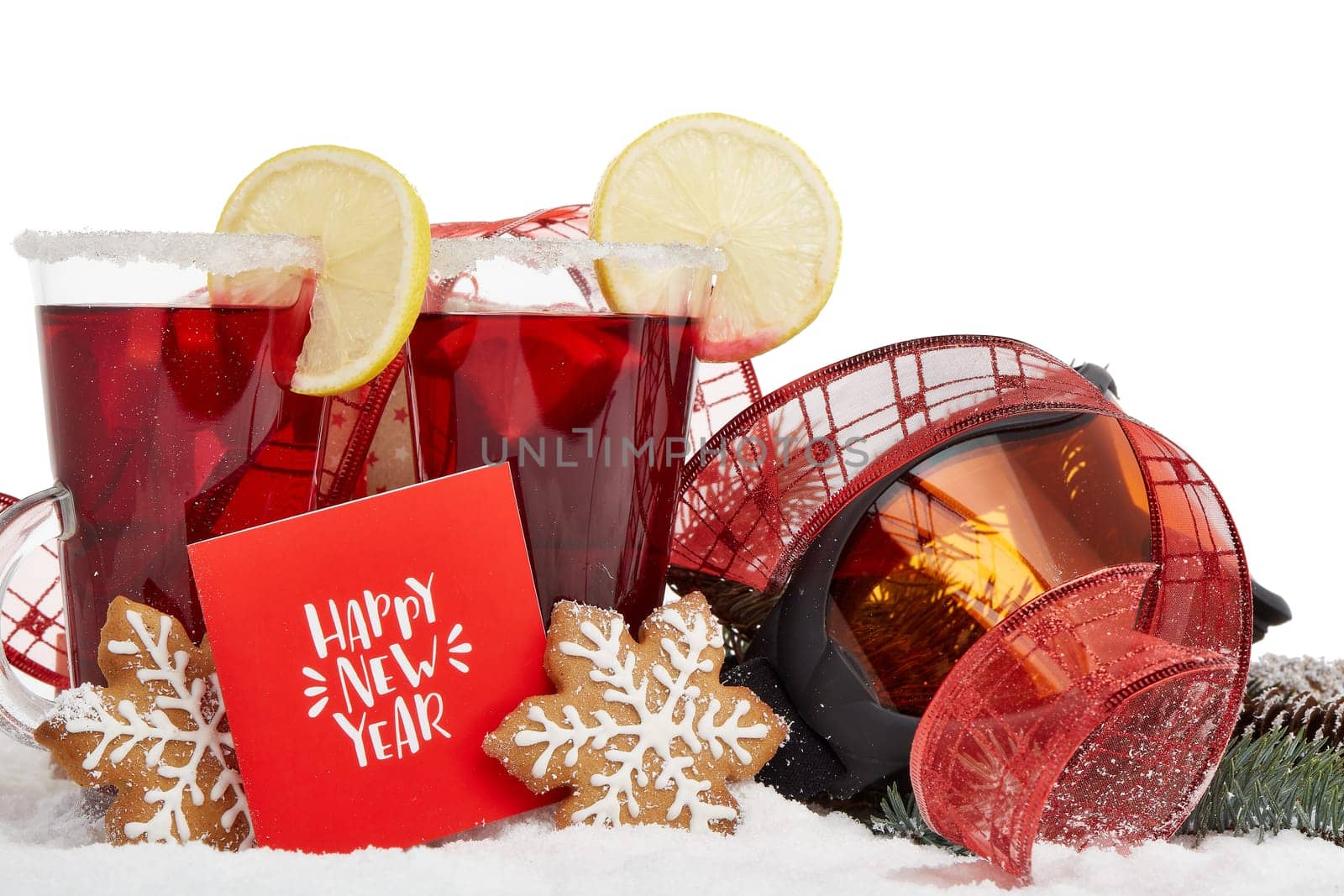 Winter holidays still life with fir tree branch, ski glasses, fruit tea, gingerbread cookies and Christmas decorations on snow on a white background. Happpy New Year. Greeting card. Winter vacation.