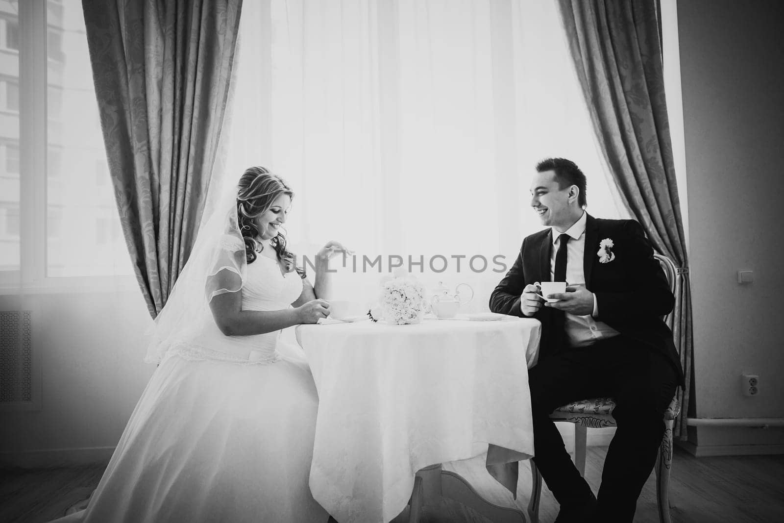 Black white photography bride and groom posing in a hotel room