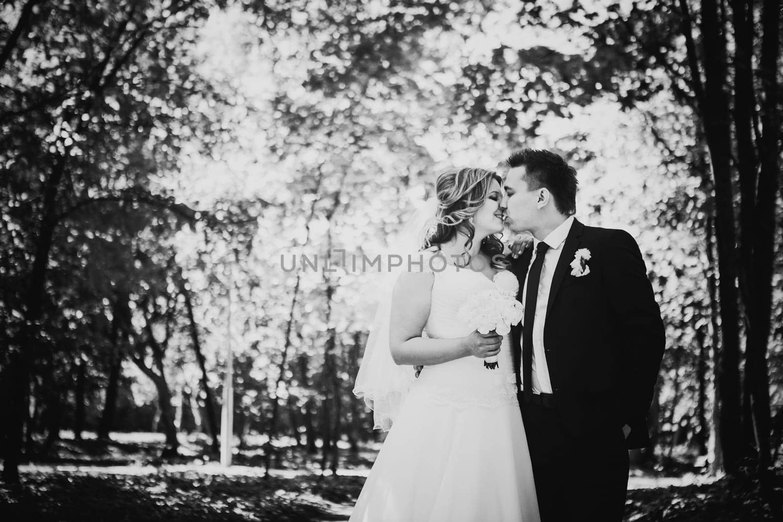 Black white photography happy couple bride and groom embracing they stand in a forest