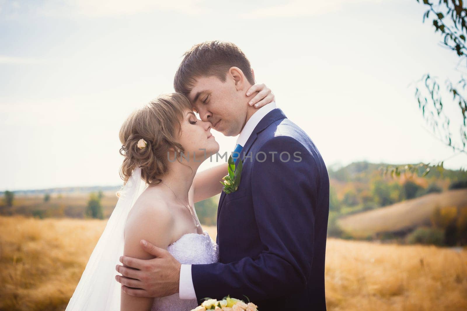 young bride and groom on the background of the field