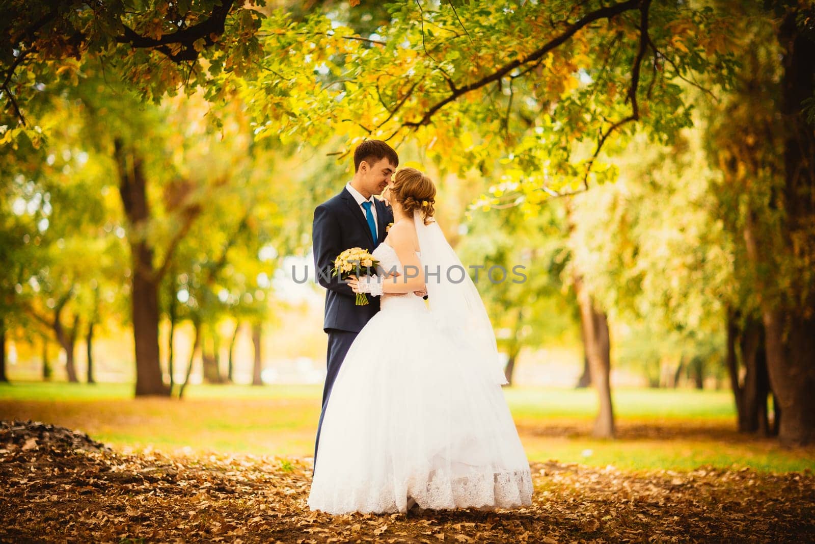young bride and groom on the background of autumn landscape