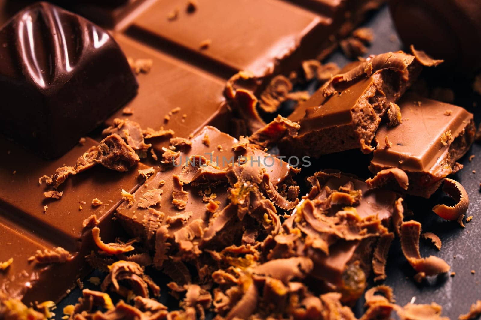 Many candy and chocolate chips on a black background