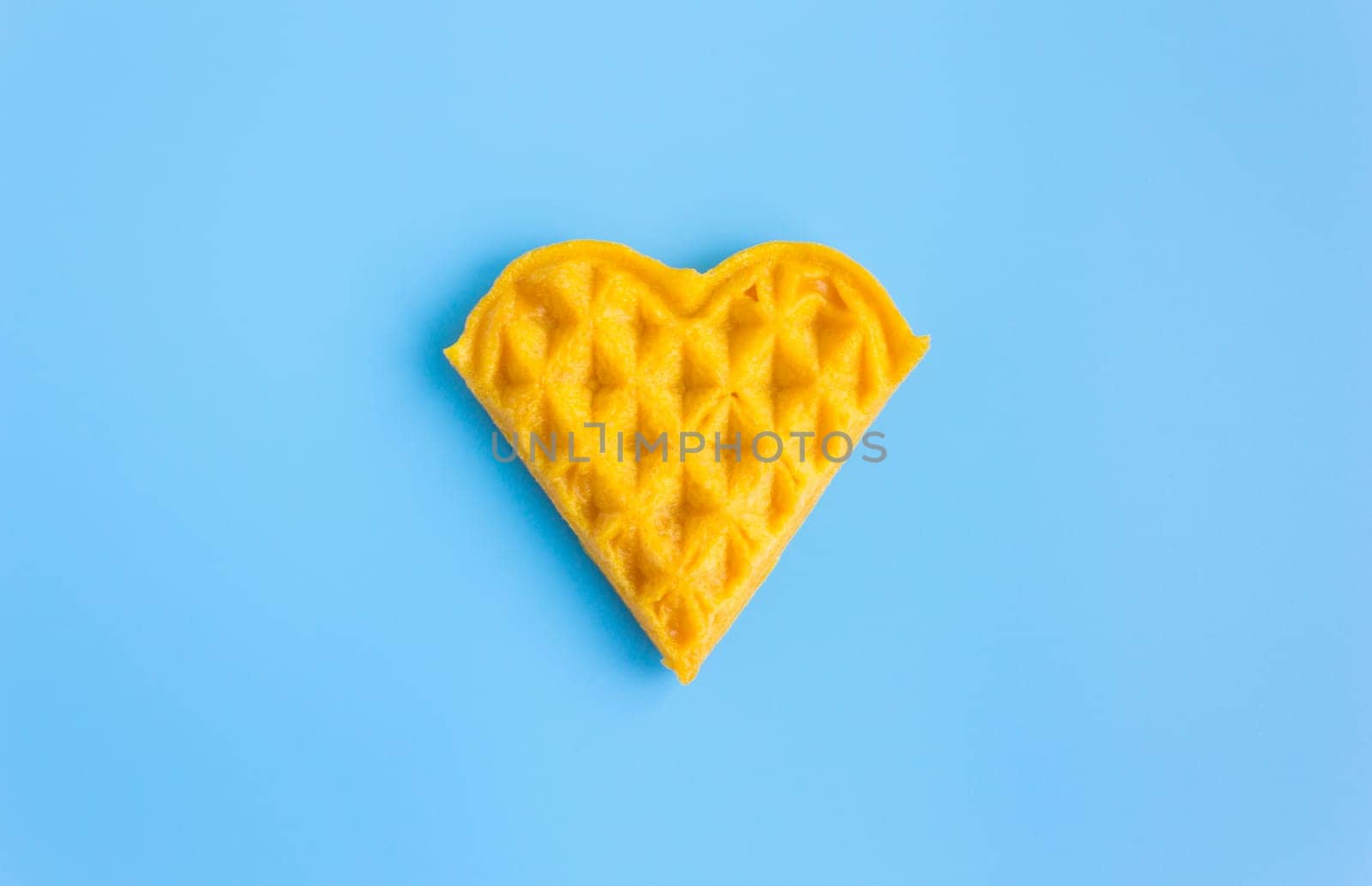 1 Piece Heart Shape Waffle on Blue Pastel Background Minimalist Style. Heart shape waffle dessert in minimalist style for food and dessert category