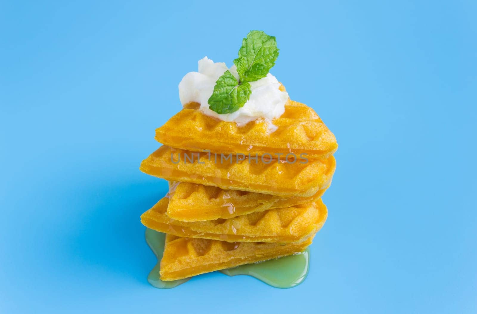 5 Pieces Heart Shape Waffle and Peppermint and Honey on Blue Pastel Background Minimalist Style. Heart shape waffle dessert in minimalist style for food and dessert category