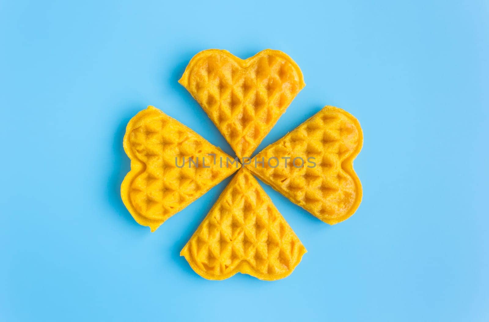 4 Pieces Waffle on Blue Pastel Background Minimalist Style. Heart shape waffle dessert in minimalist style for food and dessert category