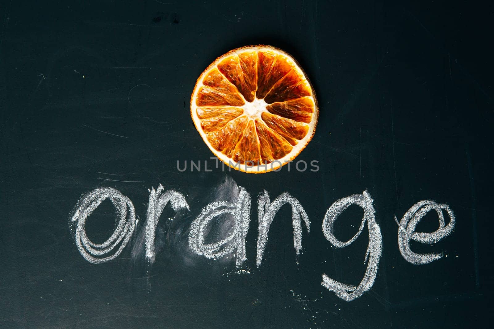 one sliced orange circle on a black background board