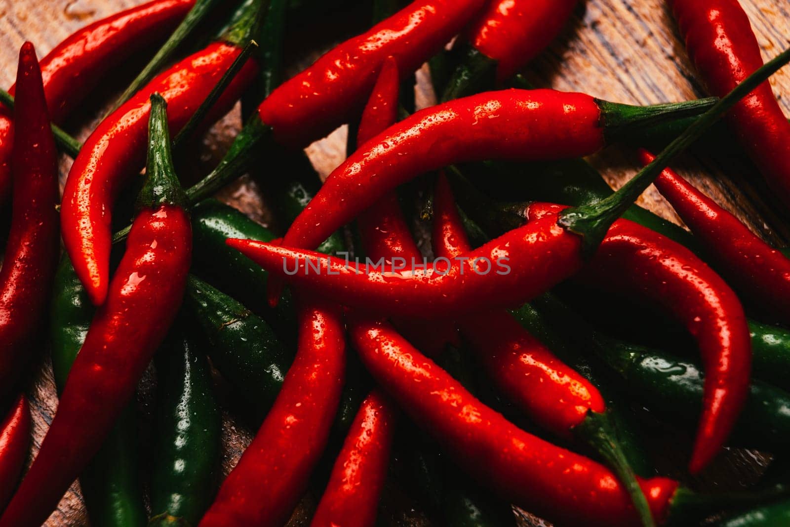red and green chili peppers close up on wooden background