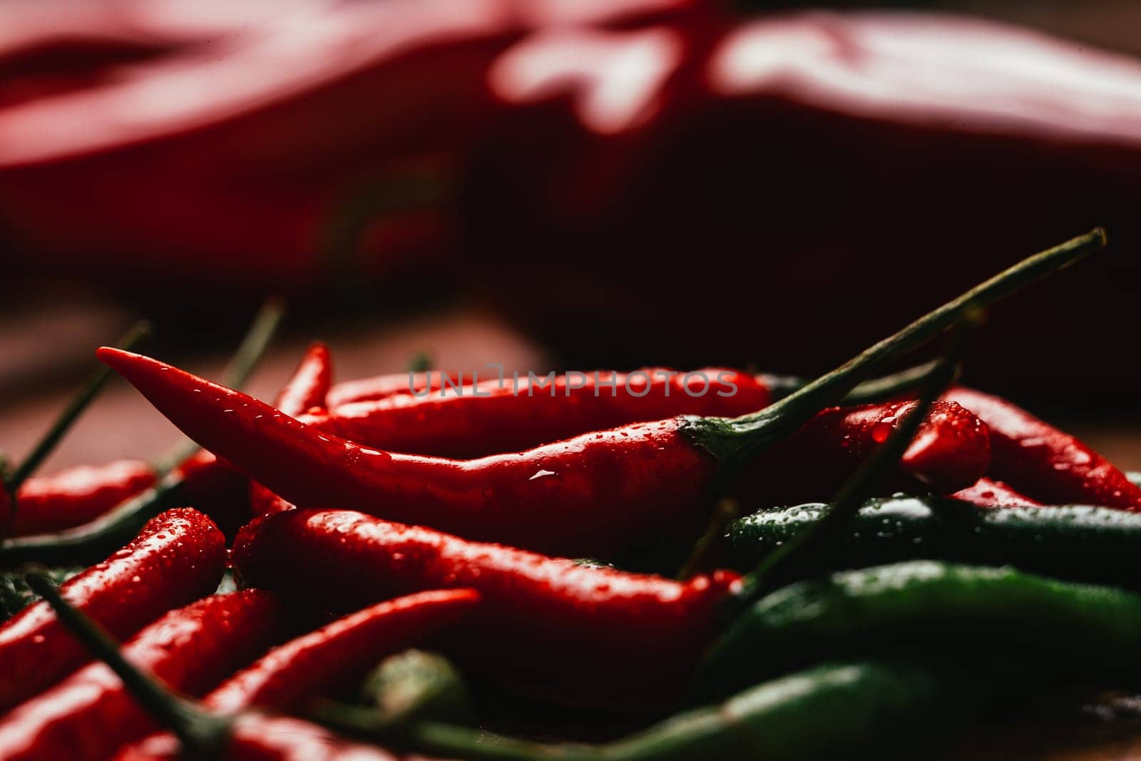 red and green chili peppers close up on wooden background