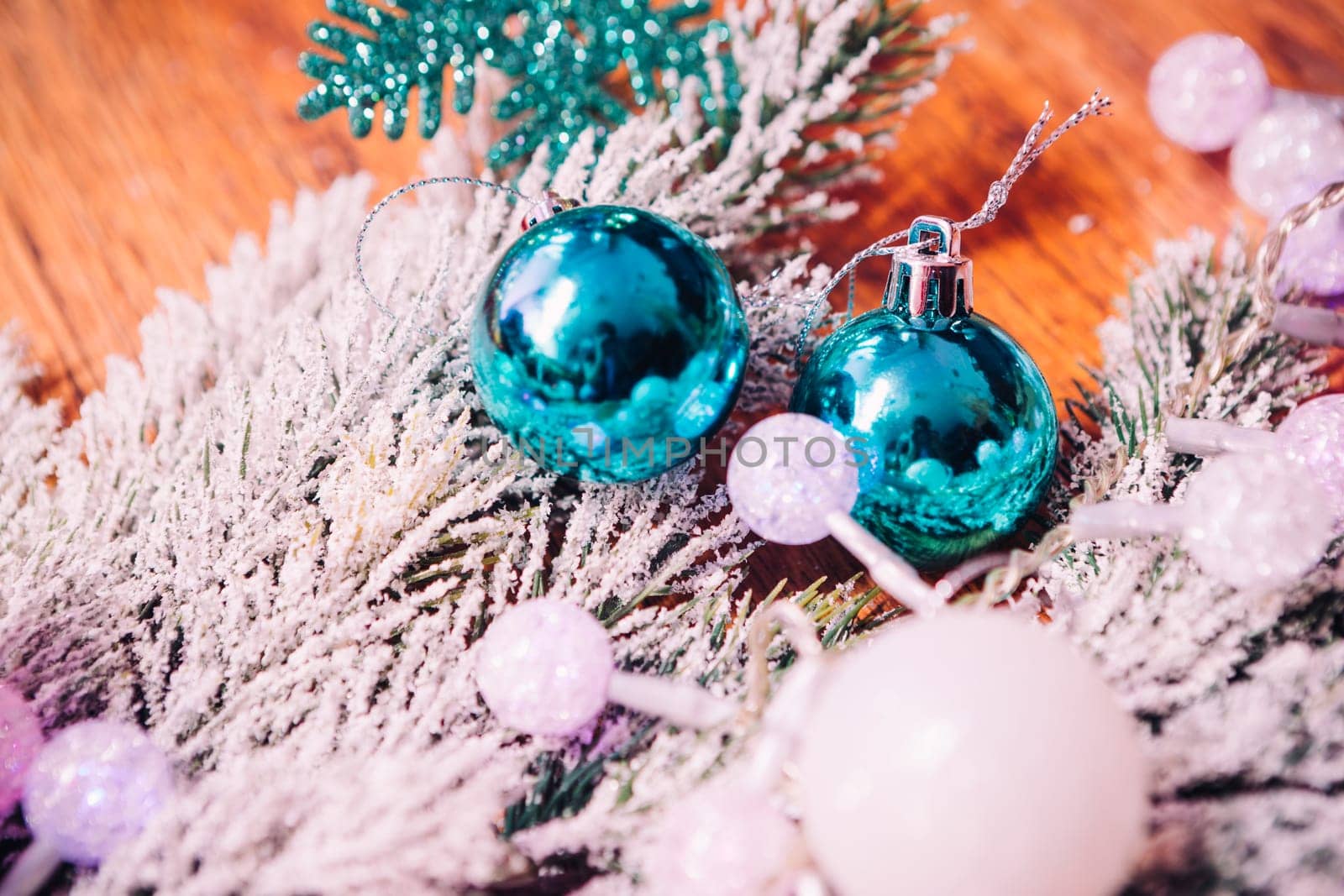 Spruce branches in the snow, and blue balls wooden background