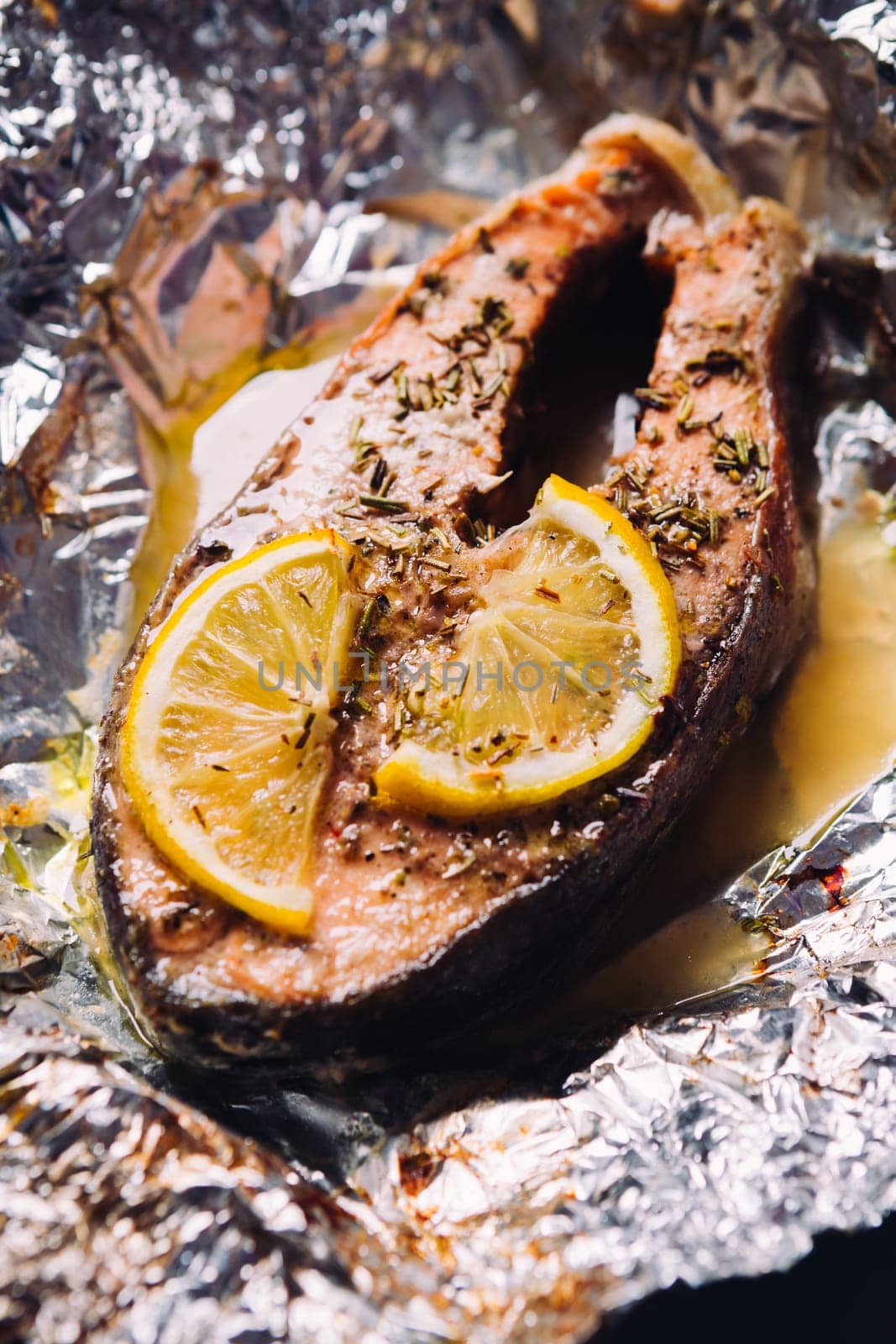 fish steak baked with lemon and herbs in foil