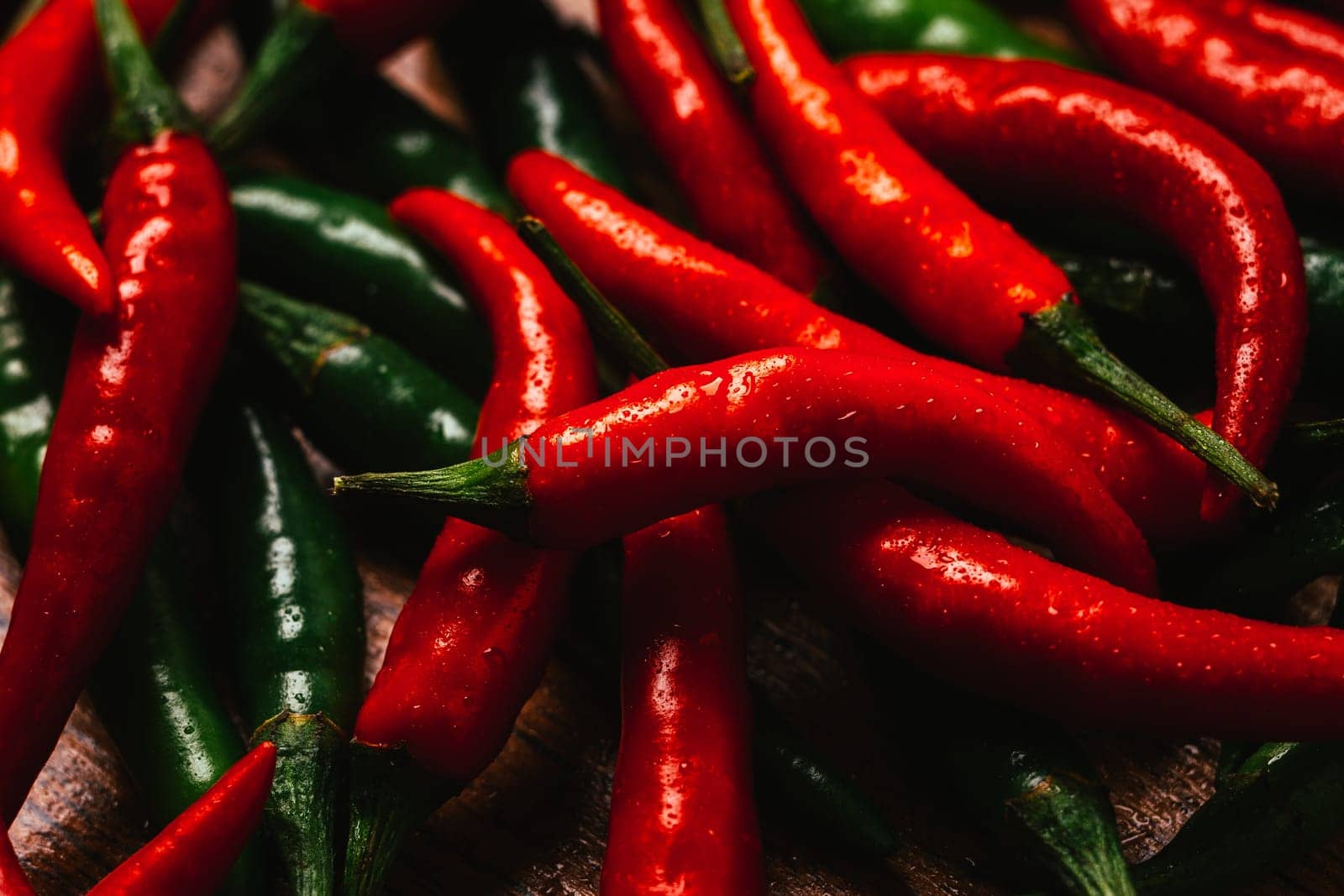 red and green chili peppers close up on wooden background