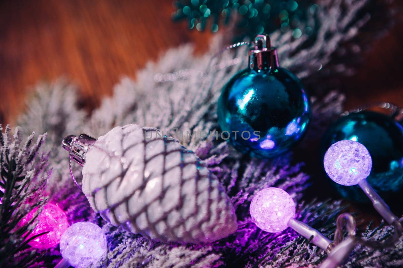 Spruce branches in the snow violet blue and white christmas balls on dark wooden background