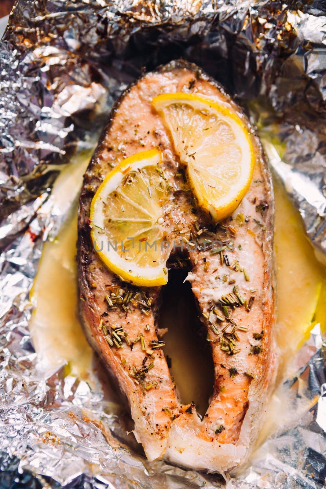 fish steak baked with lemon and herbs in foil