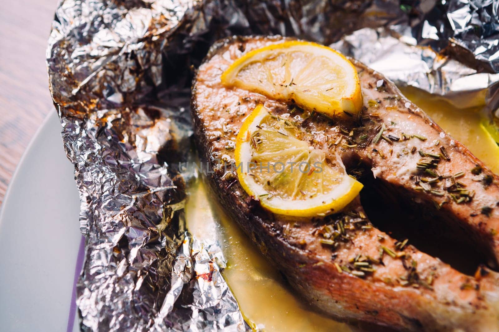 fish steak baked with lemon and herbs in foil