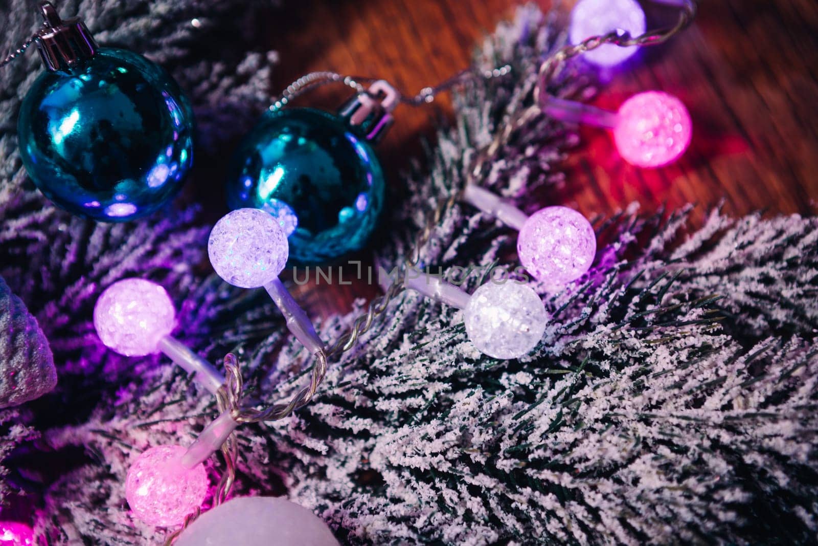 Spruce branches in the snow violet blue and white christmas balls on dark wooden background