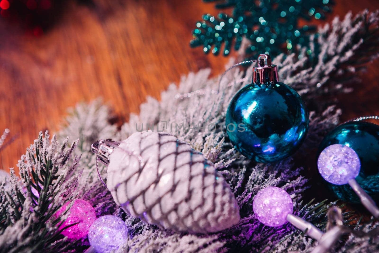 Spruce branches in the snow violet blue and white christmas balls on dark wooden background