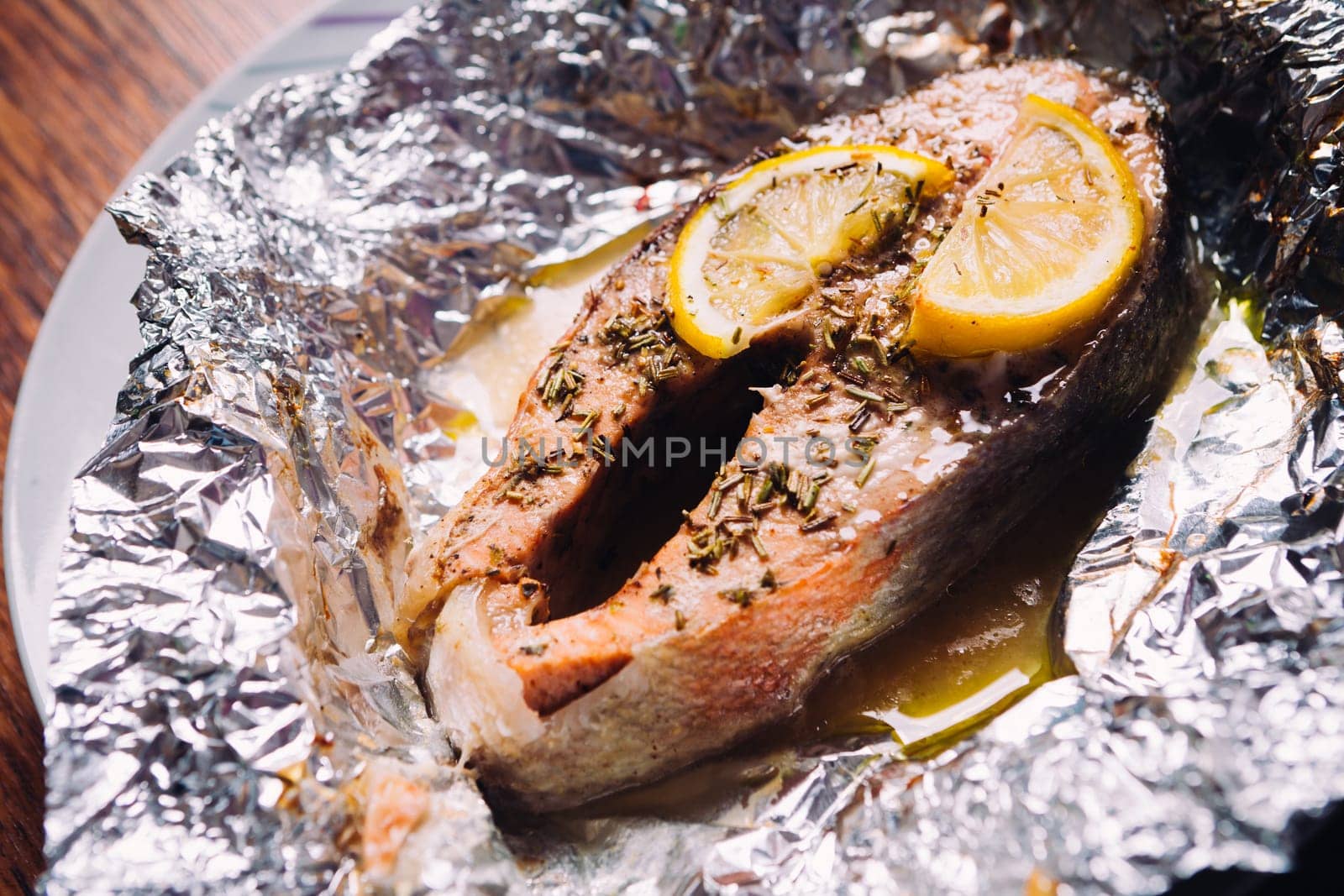 fish steak baked with lemon and herbs in foil