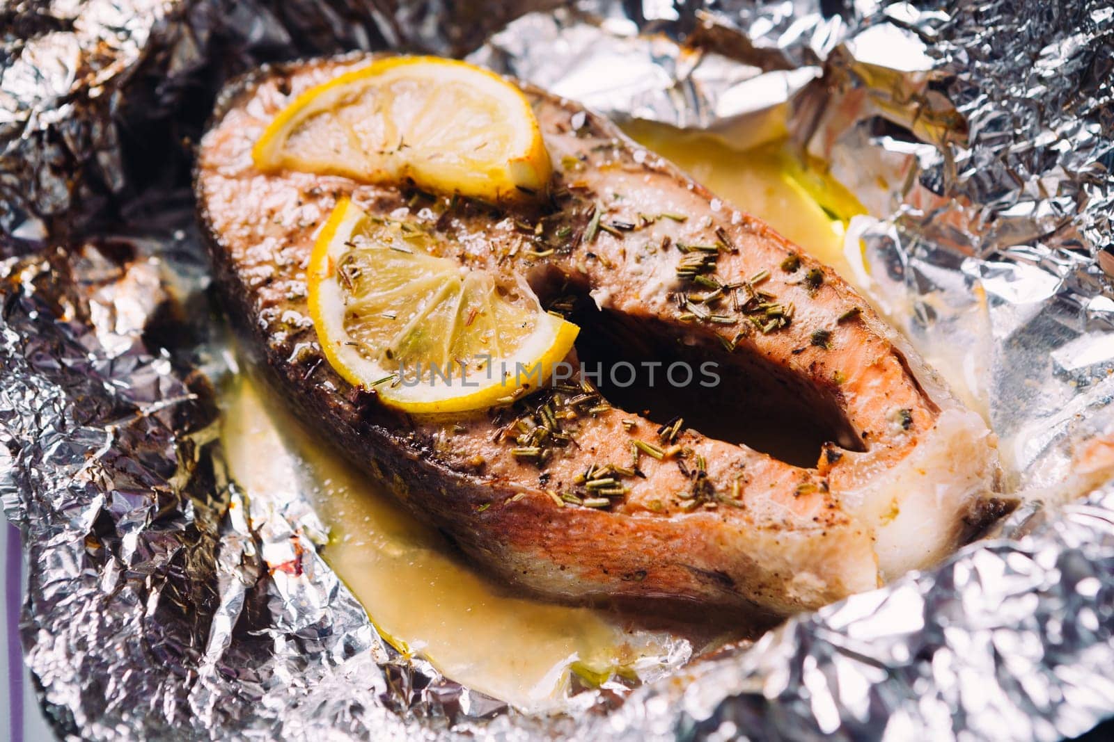 fish steak baked with lemon and herbs in foil