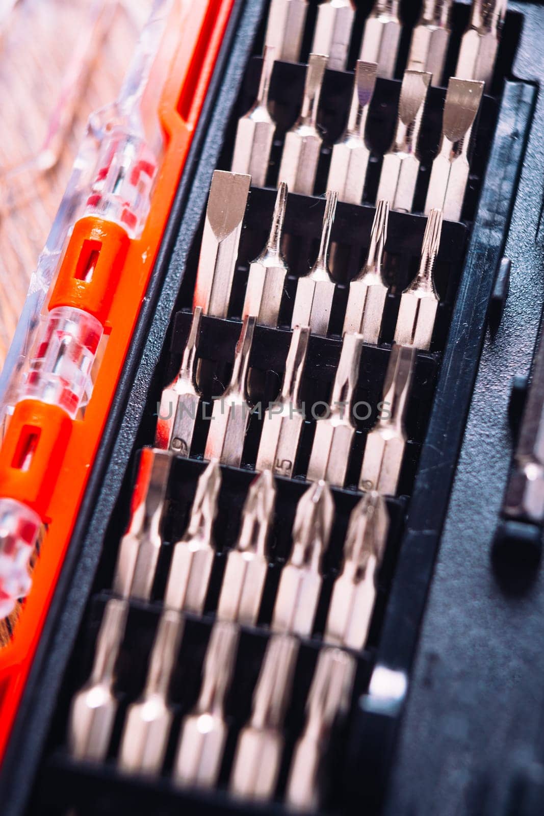 set of nozzles for screwdriver in red box on wooden background