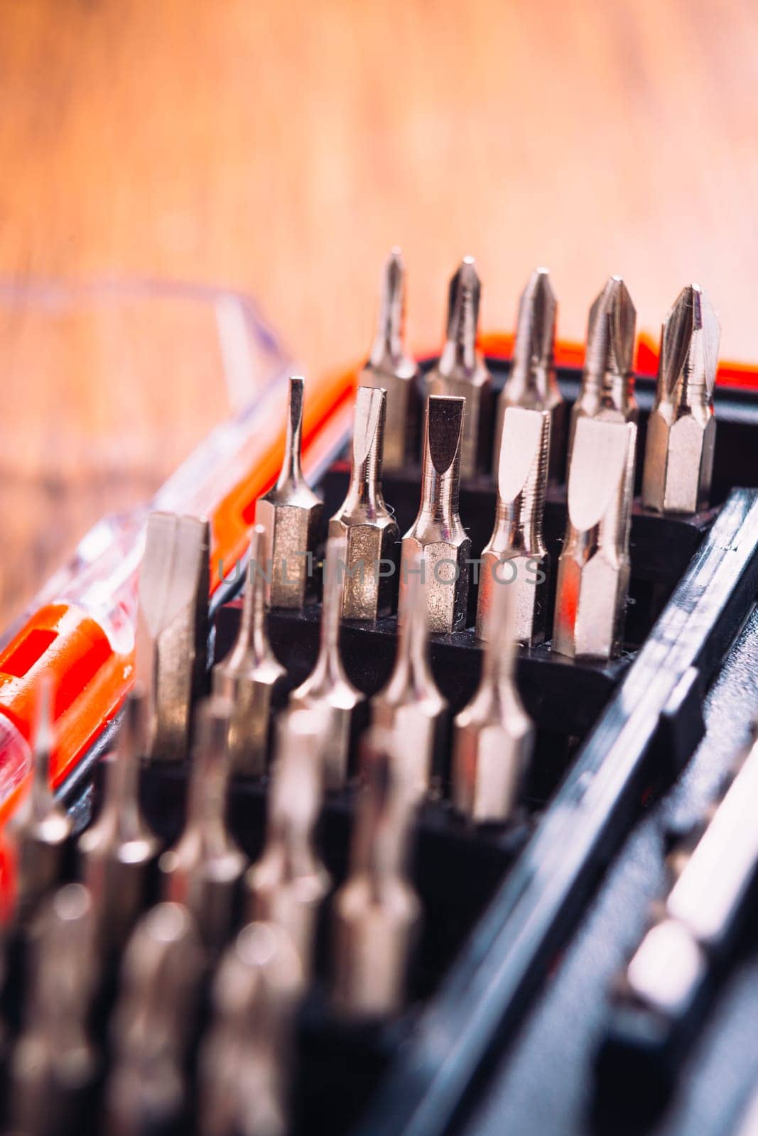 set of nozzles for screwdriver in red box on wooden background