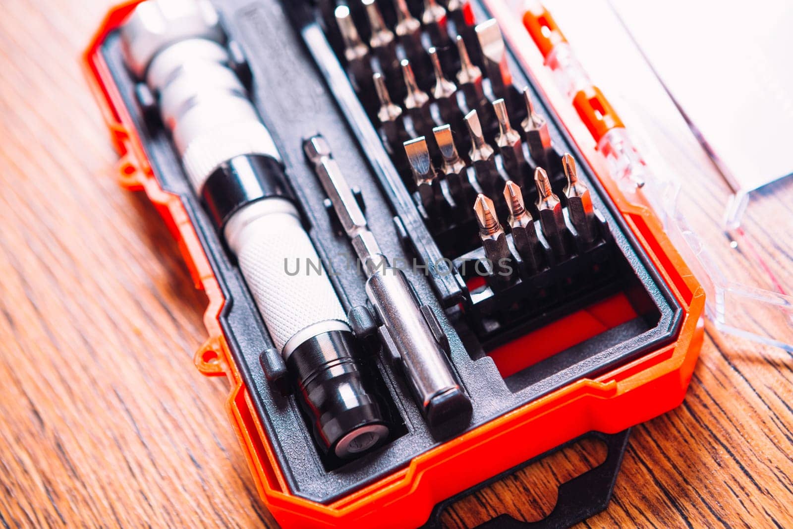 set of nozzles for screwdriver in red box on wooden background