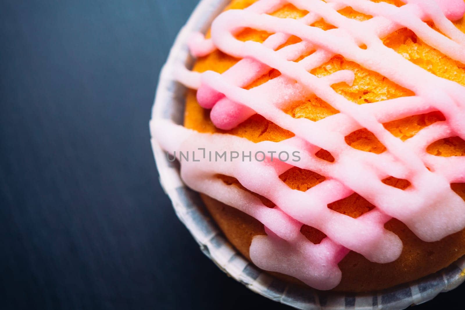 cupcake with pink frosting on a wooden background