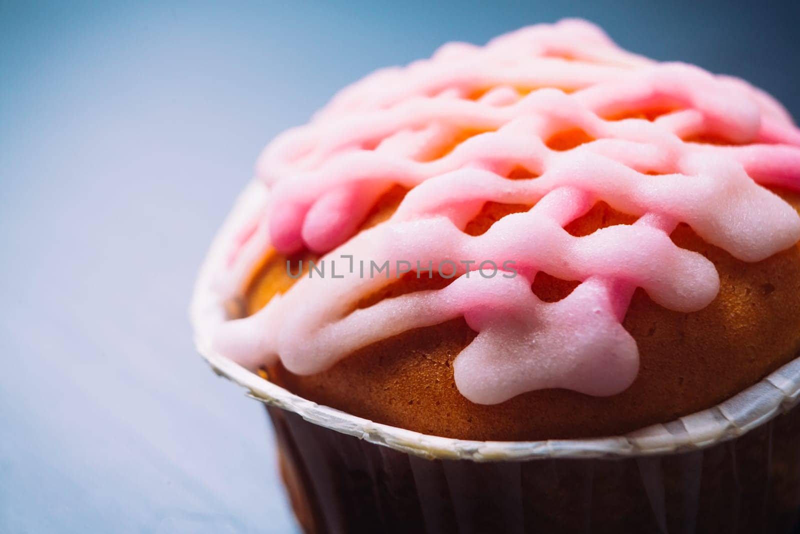 cupcake with pink frosting on a wooden background