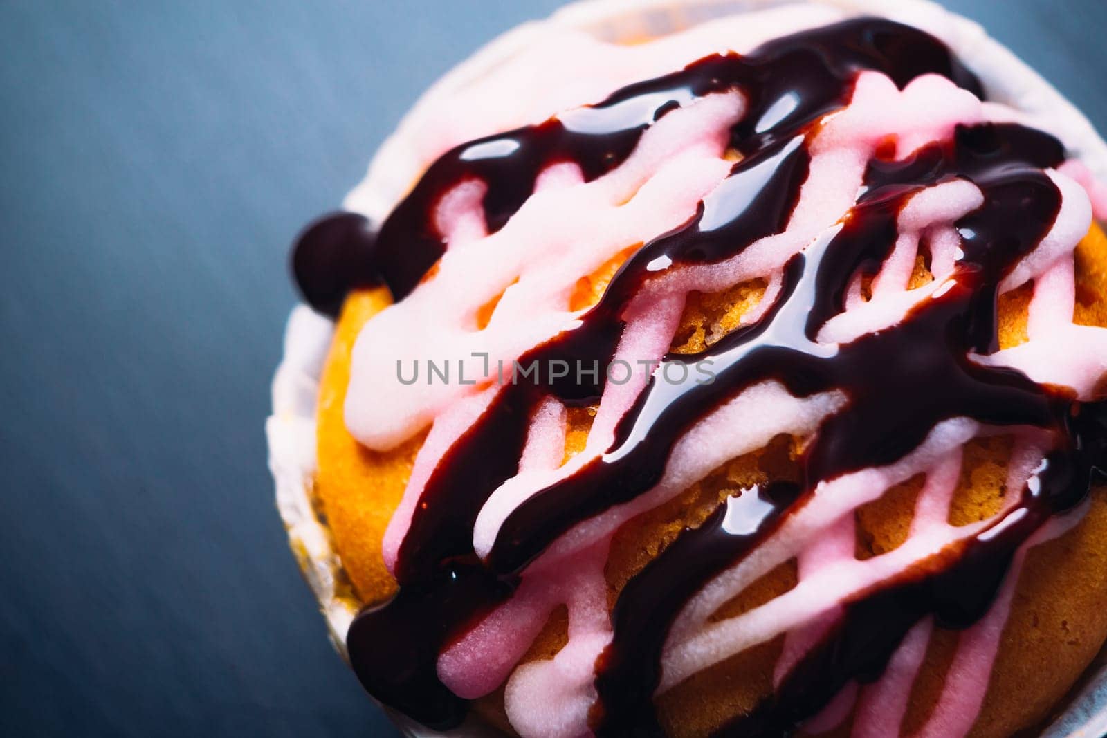 cupcake with pink frosting on a wooden background close up
