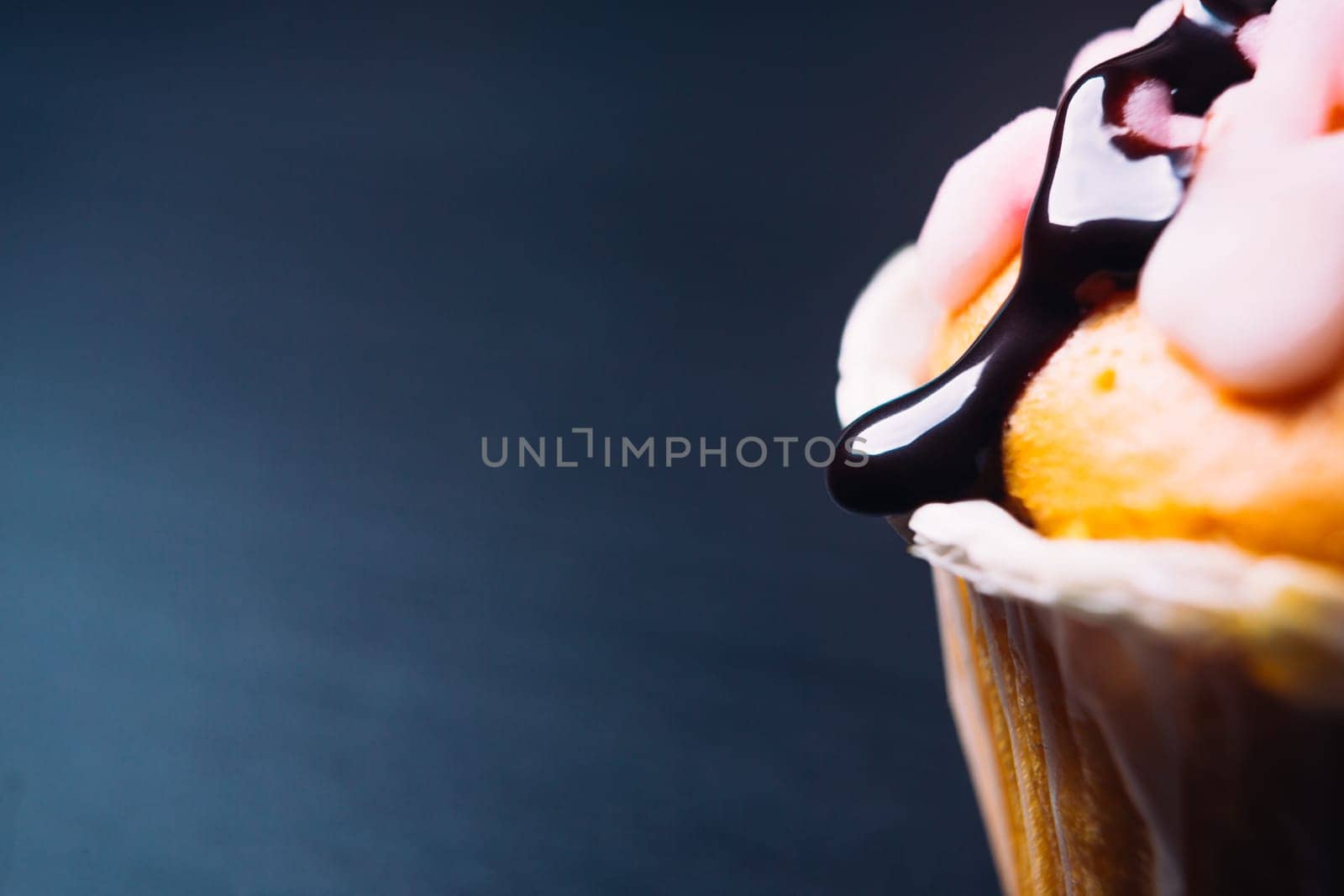 cupcake with pink frosting on a wooden background close up