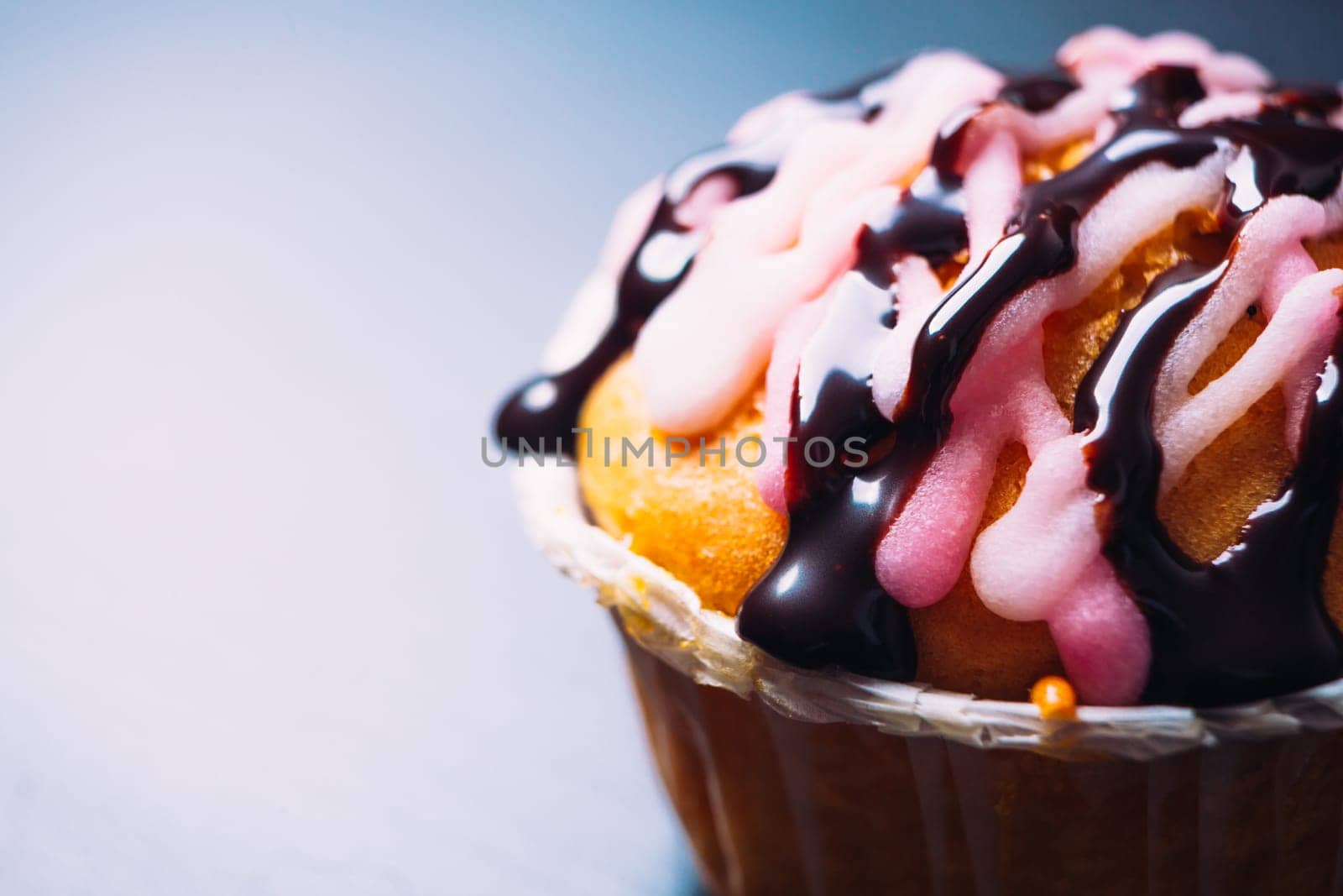 cupcake with pink frosting on a wooden background close up