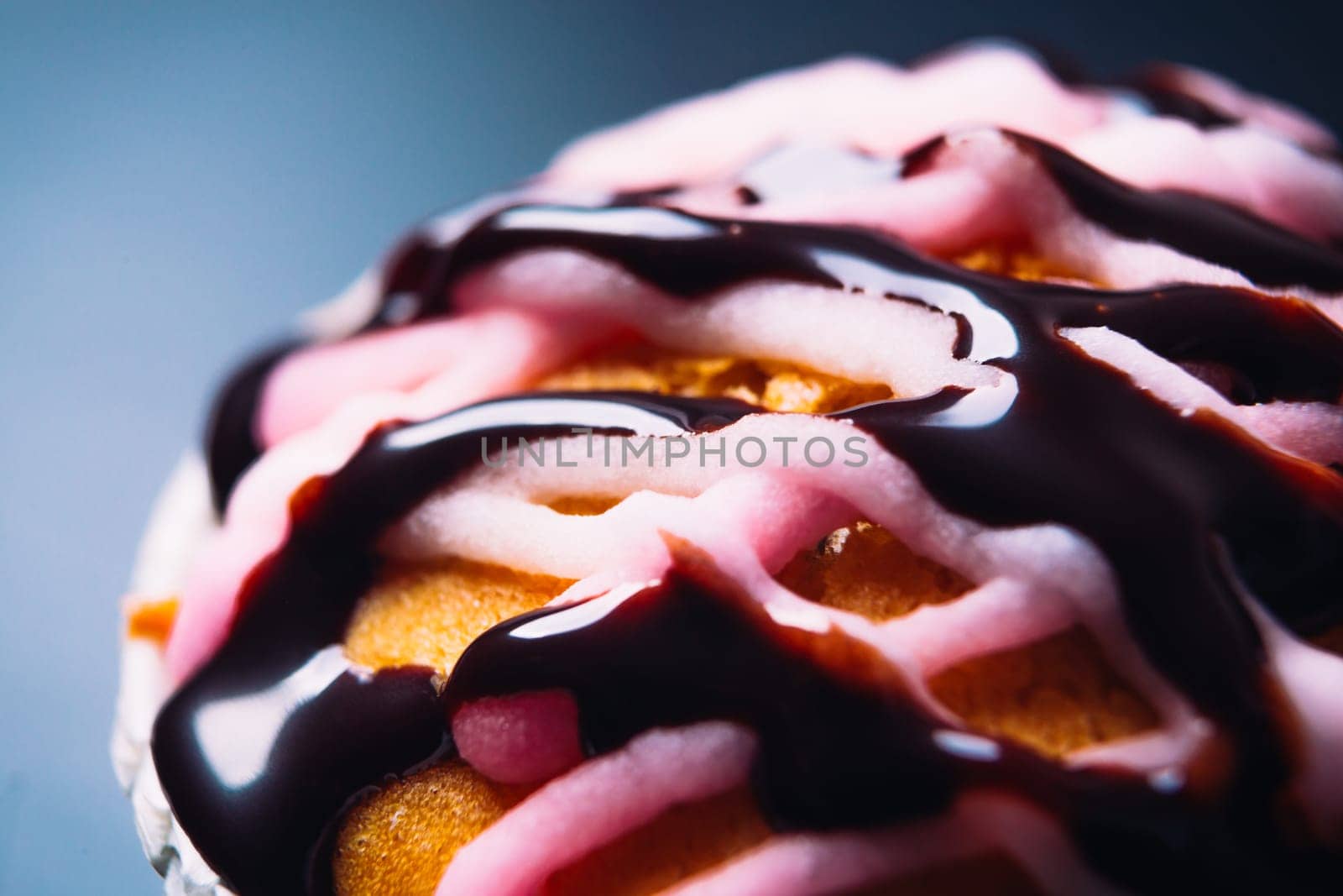 cupcake with pink frosting on a wooden background close up