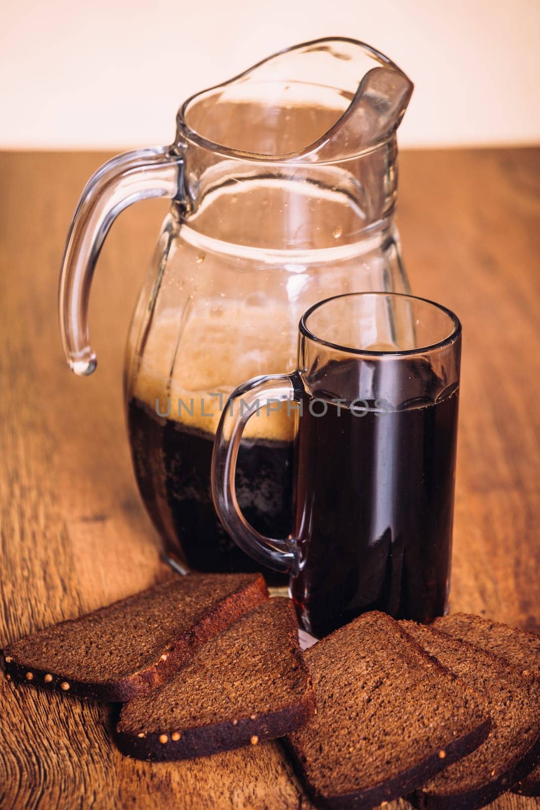 Russian brew in mug jug and loaf of rye flour on wooden background