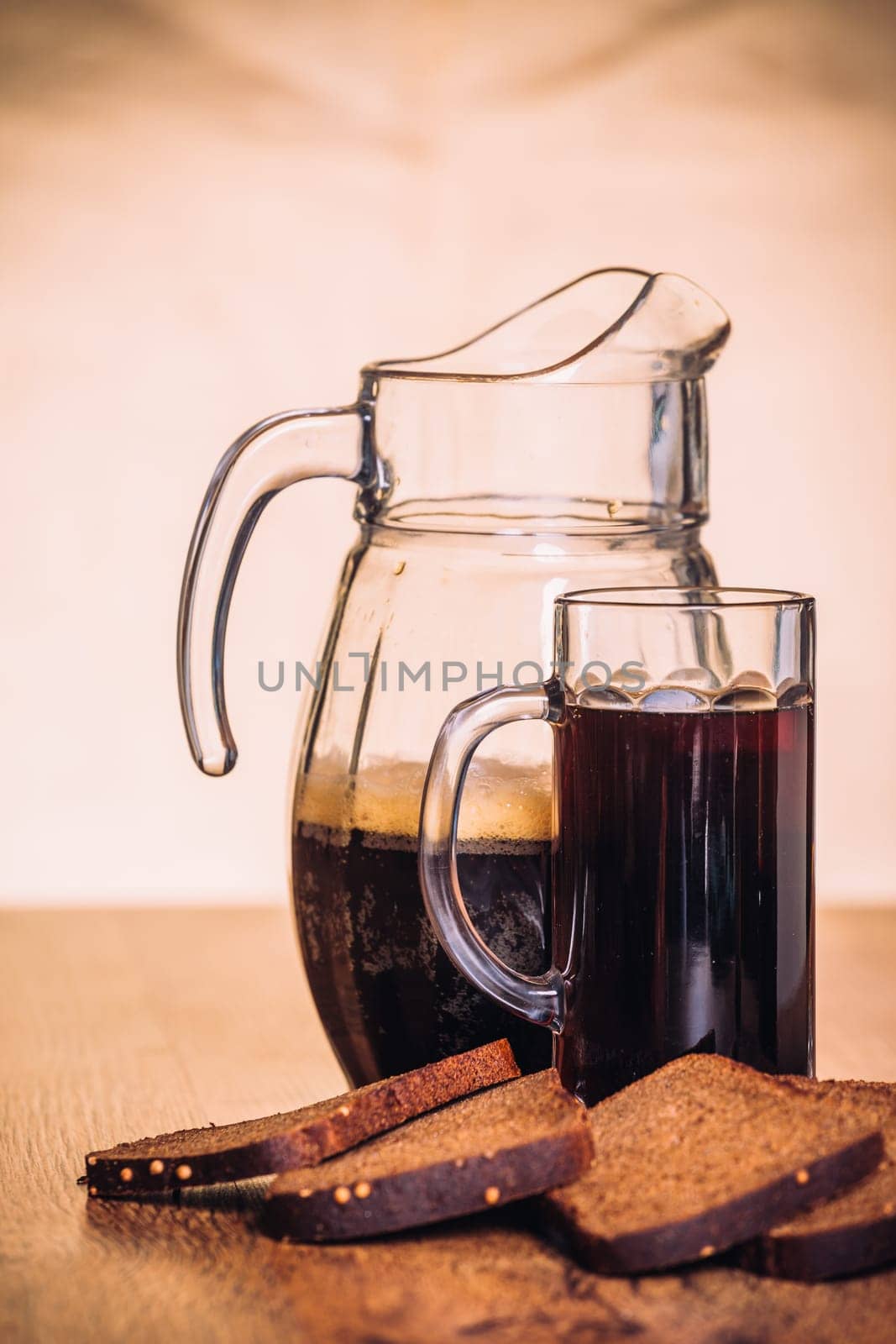 Russian brew in mug jug and loaf of rye flour on wooden background