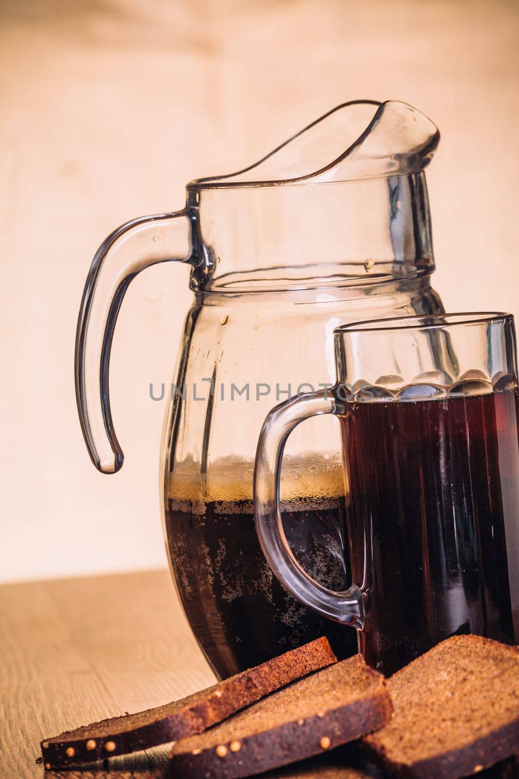 Russian brew in mug jug and loaf of rye flour on wooden background