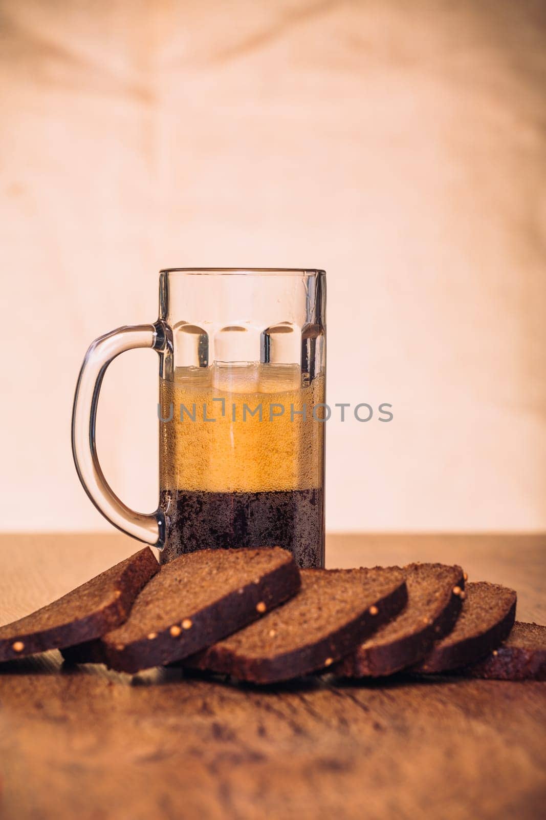 Russian brew in mug and loaf of rye flour on wooden background