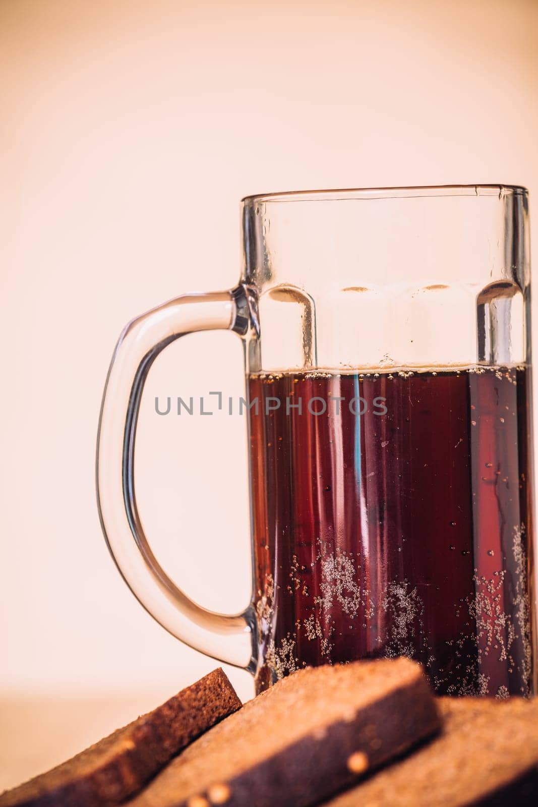 Russian brew in mug and loaf of rye flour on wooden background