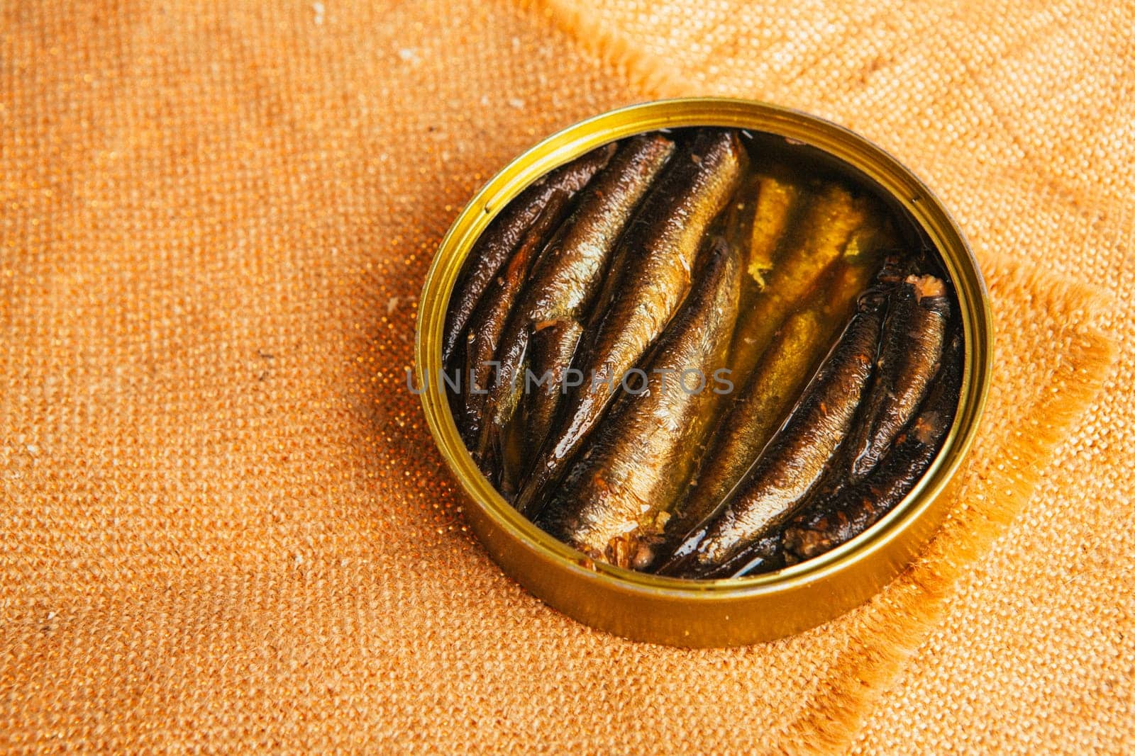 open can with of sprats on sackcloth background