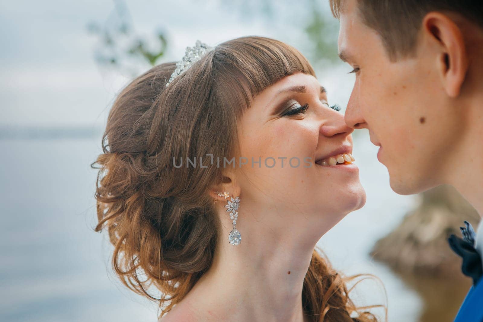 bride and groom standing and kissing in the background of the nature.