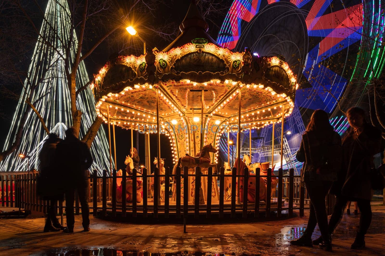 AVEIRO, PORTUGAL - CIRCA DECEMBER 2018: Fonte Nova's garden with Christmas market and colored ferris wheel near Ria de Aveiro at night.