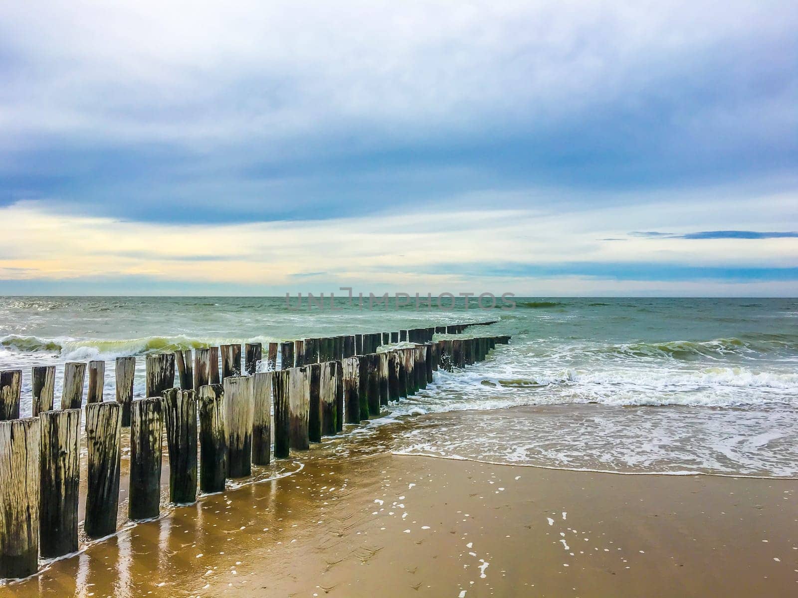 beautiful beach sea landscape ocean view with poles and wet sand