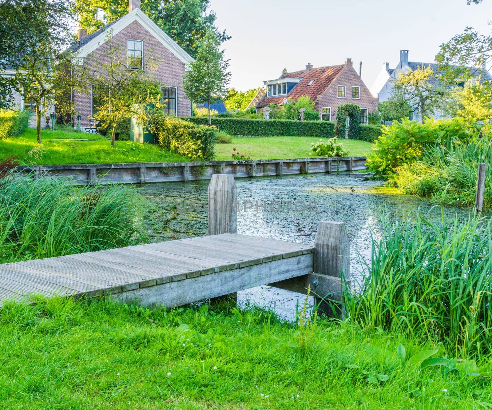 wooden pier at a pond with view on the village houses