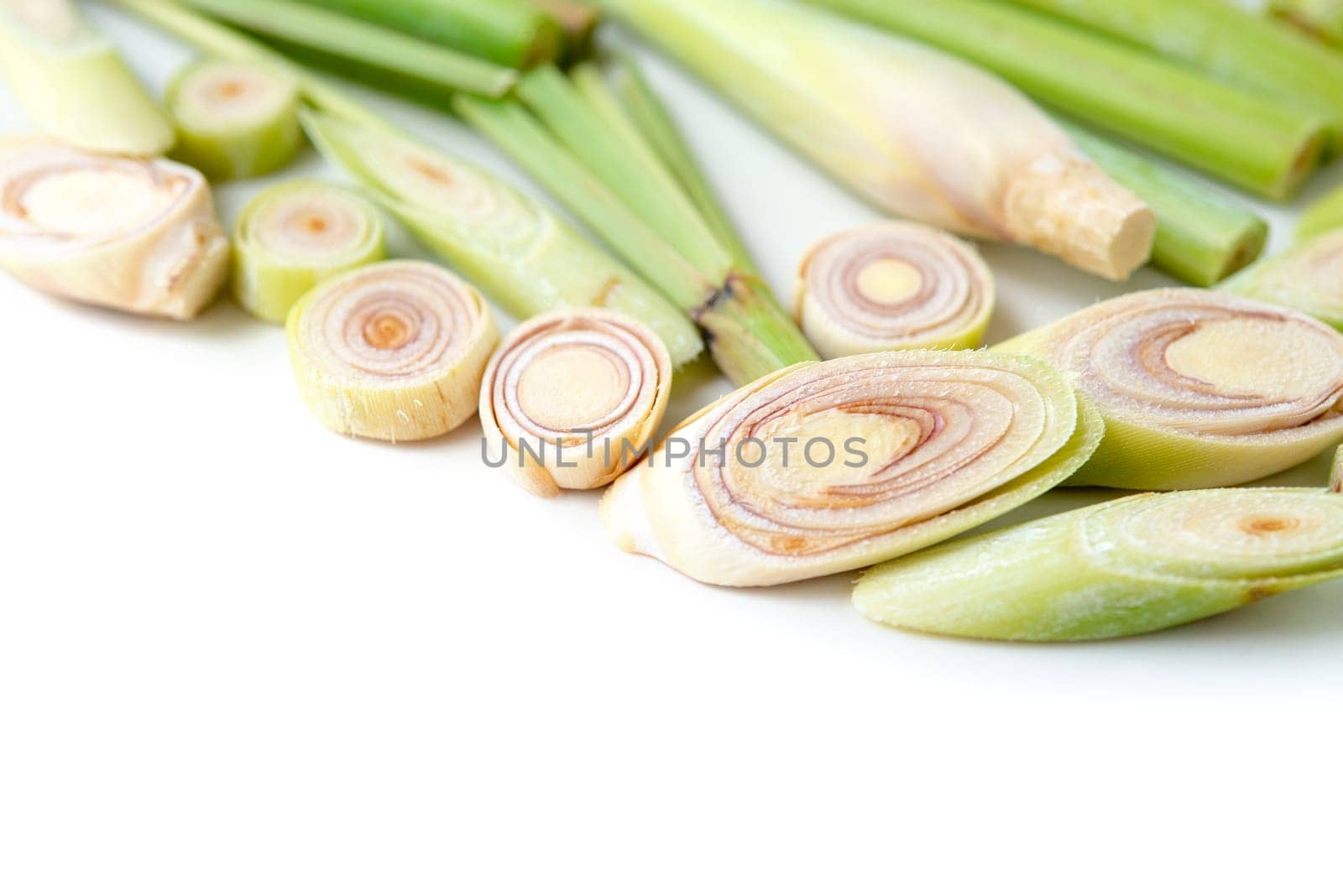 Fresh green lemongrass slices with copy space, isolated on white background.