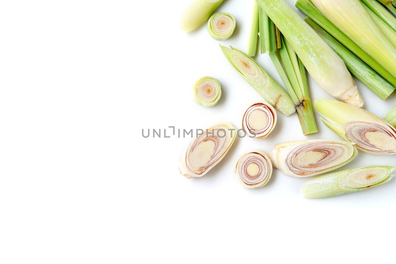 Fresh green lemongrass slices with copy space, isolated on white background.