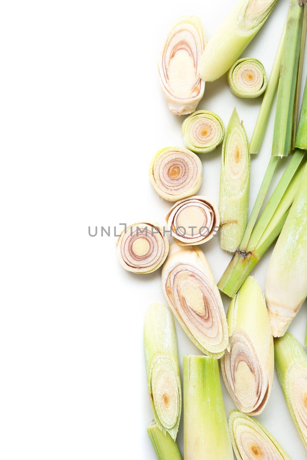 Fresh green lemongrass slices with copy space, isolated on white background.
