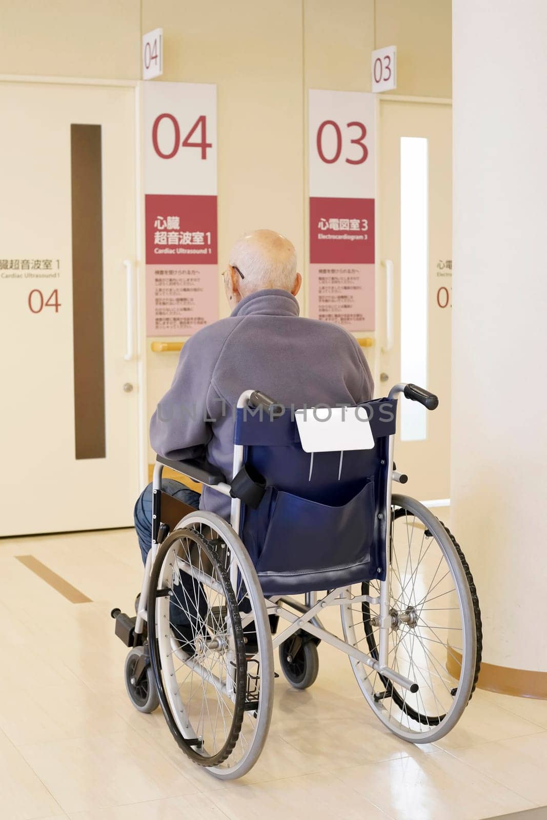 Back view of senior or elderly man sitting on wheelchair in hospital