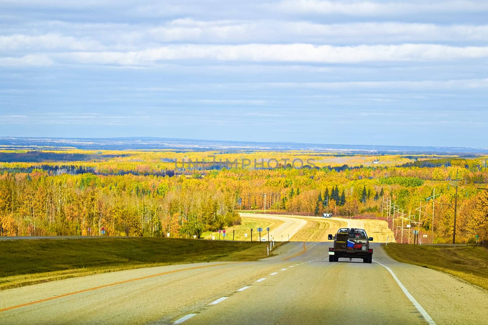 View of a vehicle traveling along a highway in the autumn.